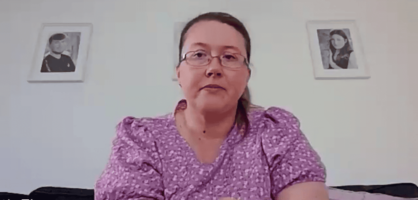 Woman in purple shirt sitting indoors