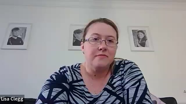 Woman with glasses and striped shirt in room.