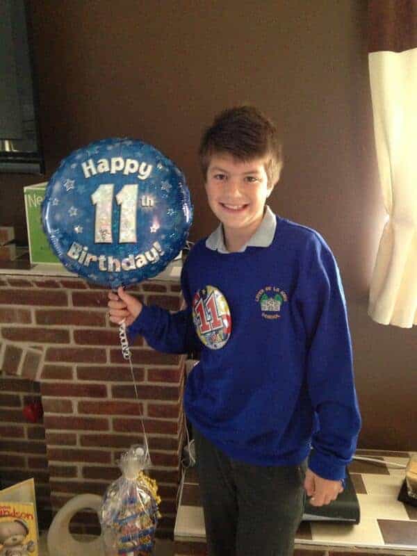 Boy with happy 11th birthday balloon.