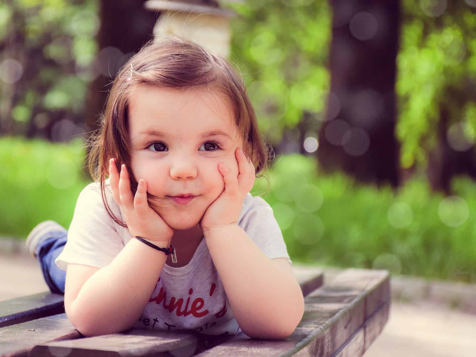 Child lying on bench, face in hands