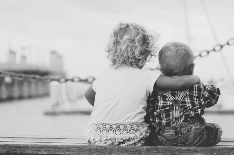 Two children sitting together on a bench