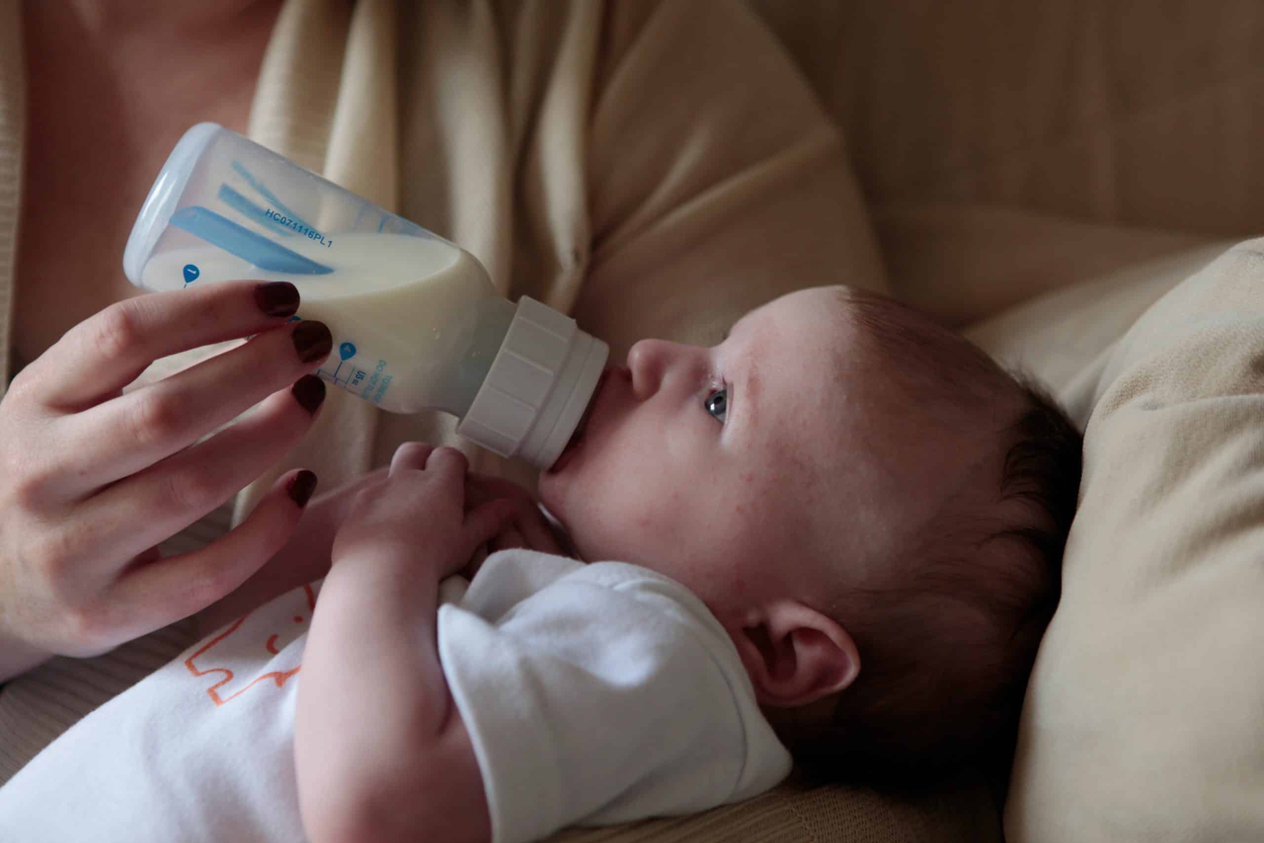 Baby being bottle fed with formula.